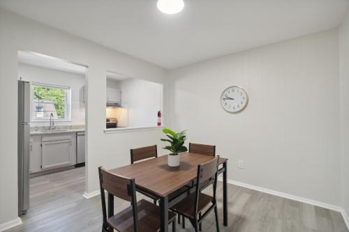 a dining room with a table and a clock on the wall at Pine Brook 518 I Spacious 2bd Garden Style Oasis in Newark