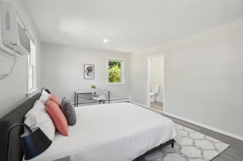 a white bedroom with a bed and a window at Pine Brook 518 I Spacious 2bd Garden Style Oasis in Newark
