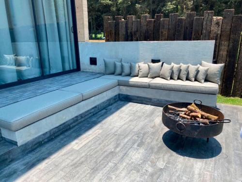 a fire pit sitting on a patio with a couch at Cabañas Avandaro Santo Boutique in Valle de Bravo