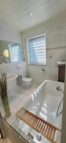 a bathroom with a tub and a toilet and a sink at My Happy Place in Goddert