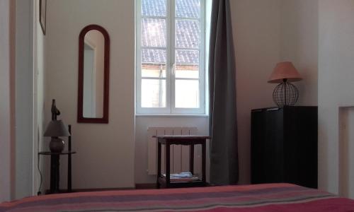 ムーランにあるL'appartement d'Aymarのベッドルーム1室(ベッド1台、窓、テーブル付)