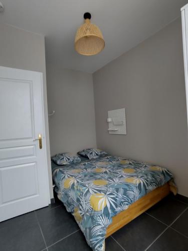 - une chambre avec un lit doté d'une couette bleue et jaune dans l'établissement Appartement 63 m2, proche des plages et des commerces, à Préfailles