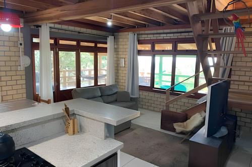 a living room with a couch and a tv at Casa dos Alpes com Jacuzzi hidro e Lareira in Santo Amaro da Imperatriz