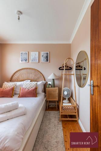 a bedroom with a large bed and a mirror at Guildford - 4 Bedroom House - Private Parking in Guildford