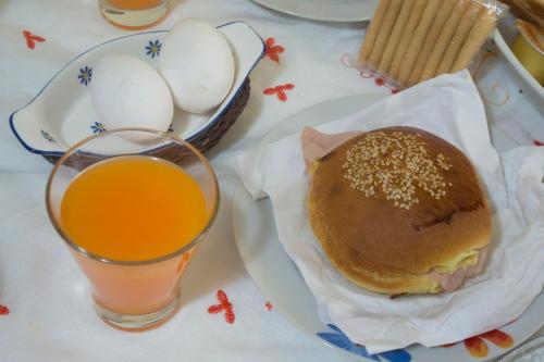 een bord met een broodje en een glas sinaasappelsap bij Alfa Quadro in Agrigento
