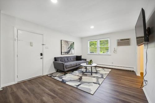 a living room with a couch and a table at Pine Brook 1108 I Pool Gym I Free Parking ! in Newark