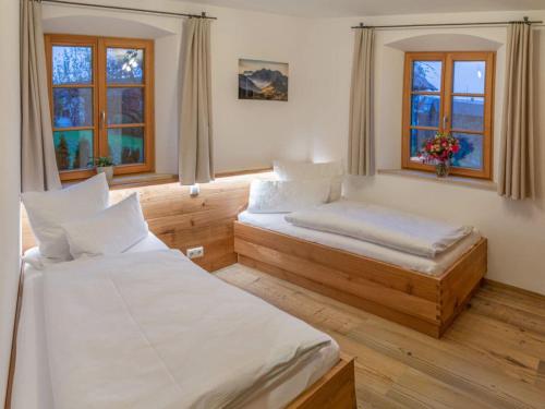 une chambre avec deux lits et deux fenêtres dans l'établissement Holiday apartment Rosenheim, à Rosenheim