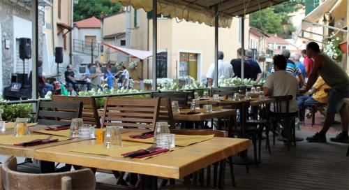 a group of tables and chairs at a restaurant at Sul Ponte Affittacamere in Pigna