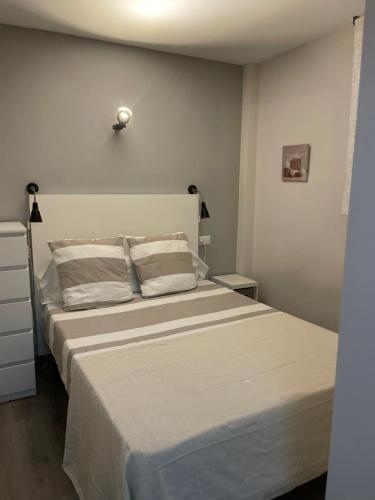 a bedroom with a large bed with white sheets at Oasis en Roses - Santa Margarita in Empuriabrava