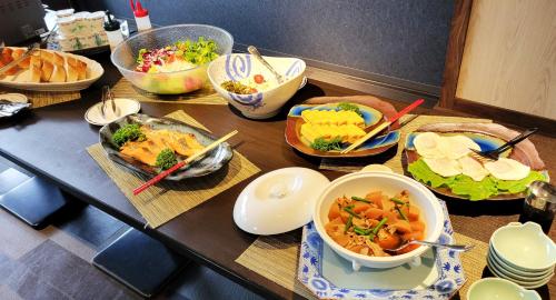 a table with many bowls of food on it at Hotel Sun Hitoyoshi in Hitoyoshi