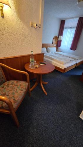 a room with a bed and a table and a chair at Hotel Morgensonne in Augustusburg
