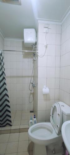 a small bathroom with a toilet and a sink at Royal Deluxe & Private Apartments - West Jakarta in Jakarta