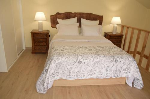 a bedroom with a white bed with two night stands at Sonho Paixão in São Vicente