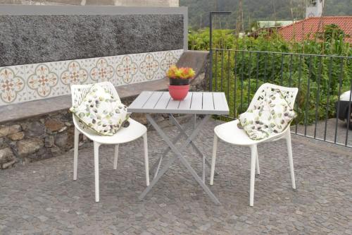 two chairs and a table with a flower pot on it at Sonho Paixão in São Vicente