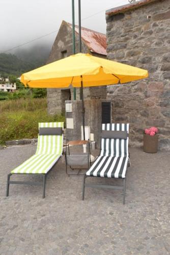 two chairs and a yellow umbrella on a patio at Sonho Paixão in São Vicente