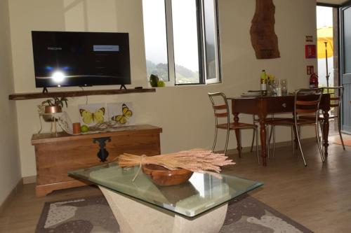 a living room with a television and a table with chairs at Sonho Paixão in São Vicente