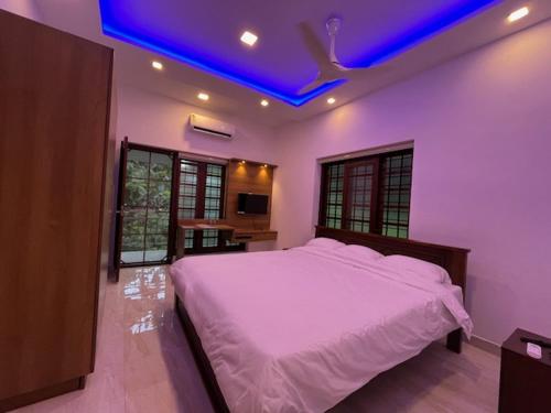 a bedroom with a white bed with a blue ceiling at Lakeshore Premier Serviced Villa in Alleppey