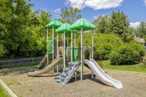 a playground with slides and umbrellas in a park at Pine Brook 1019 I Modern 15br Apartment ! Pool in Newark