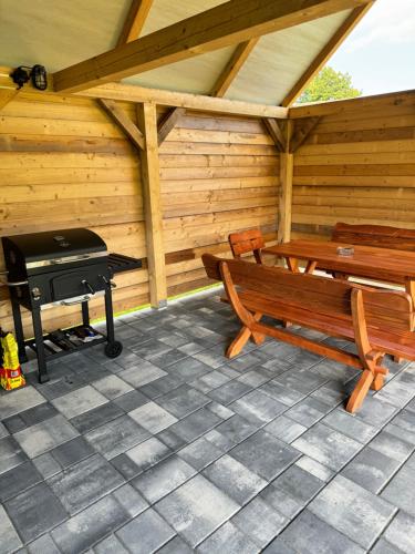 a patio with benches and a grill in a cabin at Chata Bottka in Šumiac