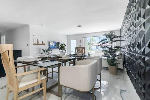 a dining room with a table and chairs at Amazing Home w Heated Pool 8 mins to the Beach in Lighthouse Point