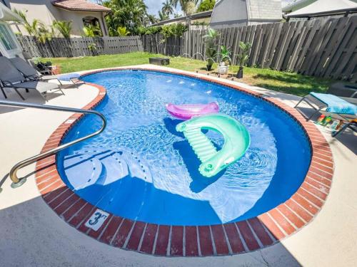 a pool with two frisbees in the water at Amazing Home w Heated Pool 8 mins to the Beach in Lighthouse Point