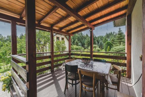a screened in porch with a table and chairs at Leśna Enklawa in Zagórze
