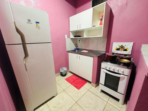 a kitchen with a white refrigerator and a stove at Vila Ws Fernandes in Manaus