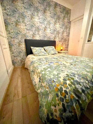 une chambre avec un lit avec un couvre-lit fleuri dans l'établissement Le cordelier, à Dijon