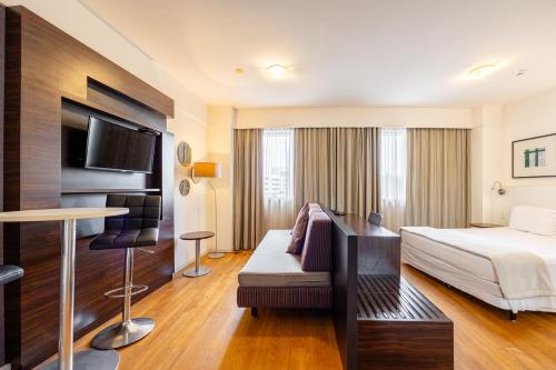 a hotel room with a bed and a desk at STD - Anora Spaces - Stadium Alphaville in Barueri