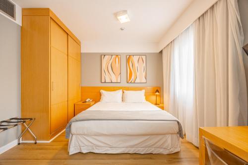 a bedroom with a large bed and a window at STD - Anora Spaces - Stadium Alphaville in Barueri