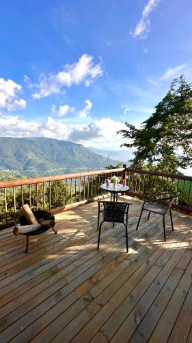 a wooden deck with two benches and a table on it at Casa Tikkun in Medellín