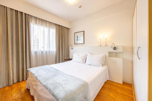 a hotel room with a white bed and a window at STD - Anora Spaces - Stadium Alphaville in Barueri