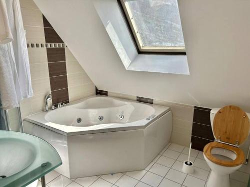 une salle de bain avec une baignoire, des toilettes et un lavabo dans l'établissement Maison Familiale, Détente au Bord de la Mer, à Larmor-Plage