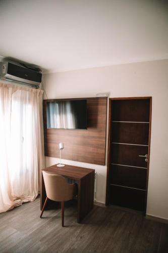 a room with a desk with a chair and a window at Catriel Suites in Catriel