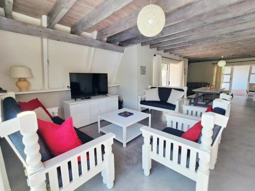 a living room with white furniture and red pillows at Beach you to it - Sedgefield in Sedgefield
