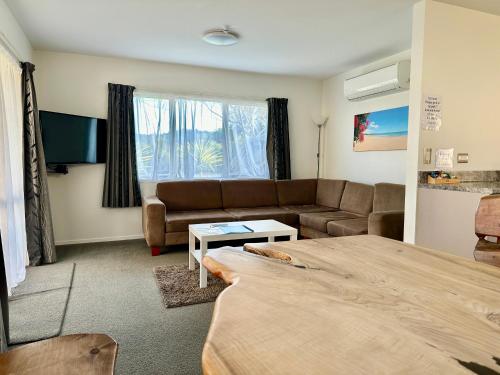a living room with a couch and a table at The Olive Motel in Coromandel Town