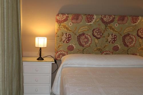 a bedroom with a bed and a lamp on a dresser at Los Balcones del Molinero in Vejer de la Frontera