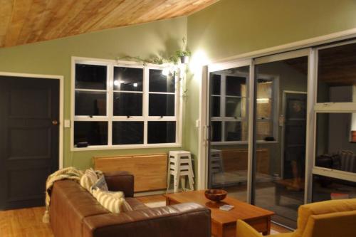 a living room with a couch and a table at The Rimu Hut - Off-grid Luxury riverside cabin in Te Anga