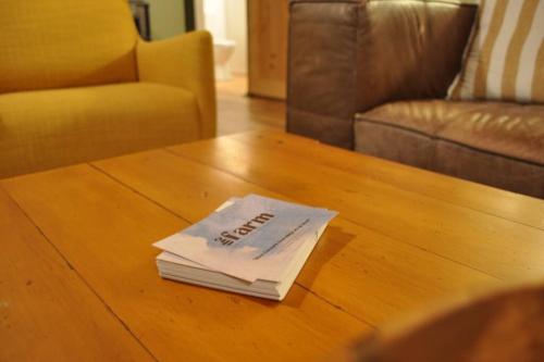 a book sitting on top of a coffee table at The Rimu Hut - Off-grid Luxury riverside cabin in Te Anga