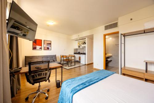 a bedroom with a bed and a desk with a television at STD - Anora Spaces - Stadium Alphaville in Barueri