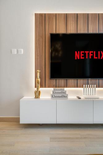 a tv sitting on top of a white entertainment center at Yas Pearl - 2BD by SLV in Abu Dhabi