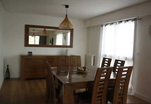une salle à manger avec une table, des chaises et un miroir dans l'établissement Appartement moderne 3 ch-5pers- 15min de Paris, à Enghien-les-Bains