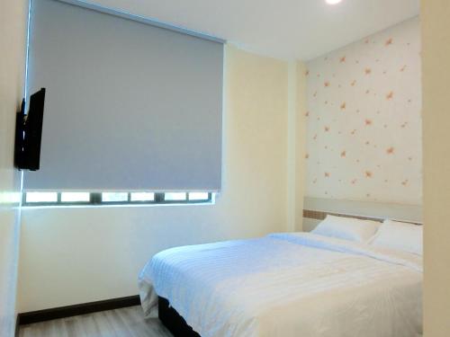 En eller flere senge i et værelse på Hotel Alor Gajah
