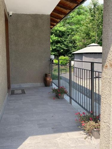a porch of a house with a fence and flowers at La casa delle Sante in Capo di Ponte