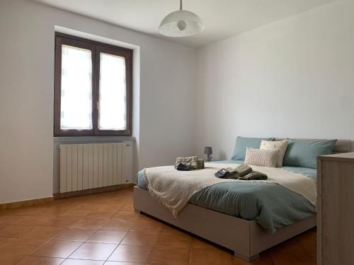 a bedroom with a bed in a white room at La casa delle Sante in Capo di Ponte