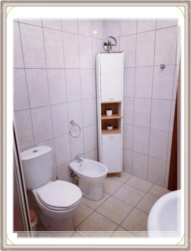 a white bathroom with a toilet and a sink at Casa do Rossio in Fornos