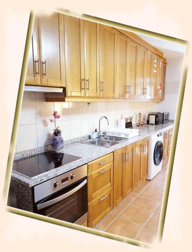 a kitchen with wooden cabinets and a sink at Casa do Rossio in Fornos