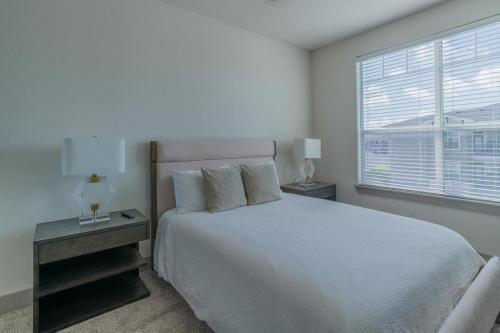 a white bedroom with a large bed and a window at Landing at The Grayson - 1 Bedroom in Cypressdale in Spring