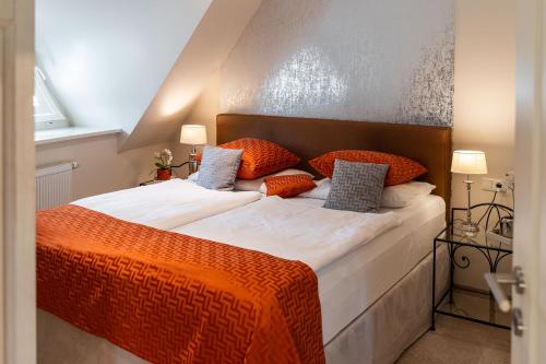a bedroom with a large bed with an orange blanket at Apartmenthaus Haus Sonne I direkt am Strand in Dierhagen