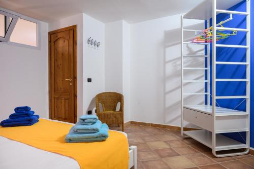 een slaapkamer met een geel bed en een boekenplank bij Nice and cozy apartment in Àrbatax